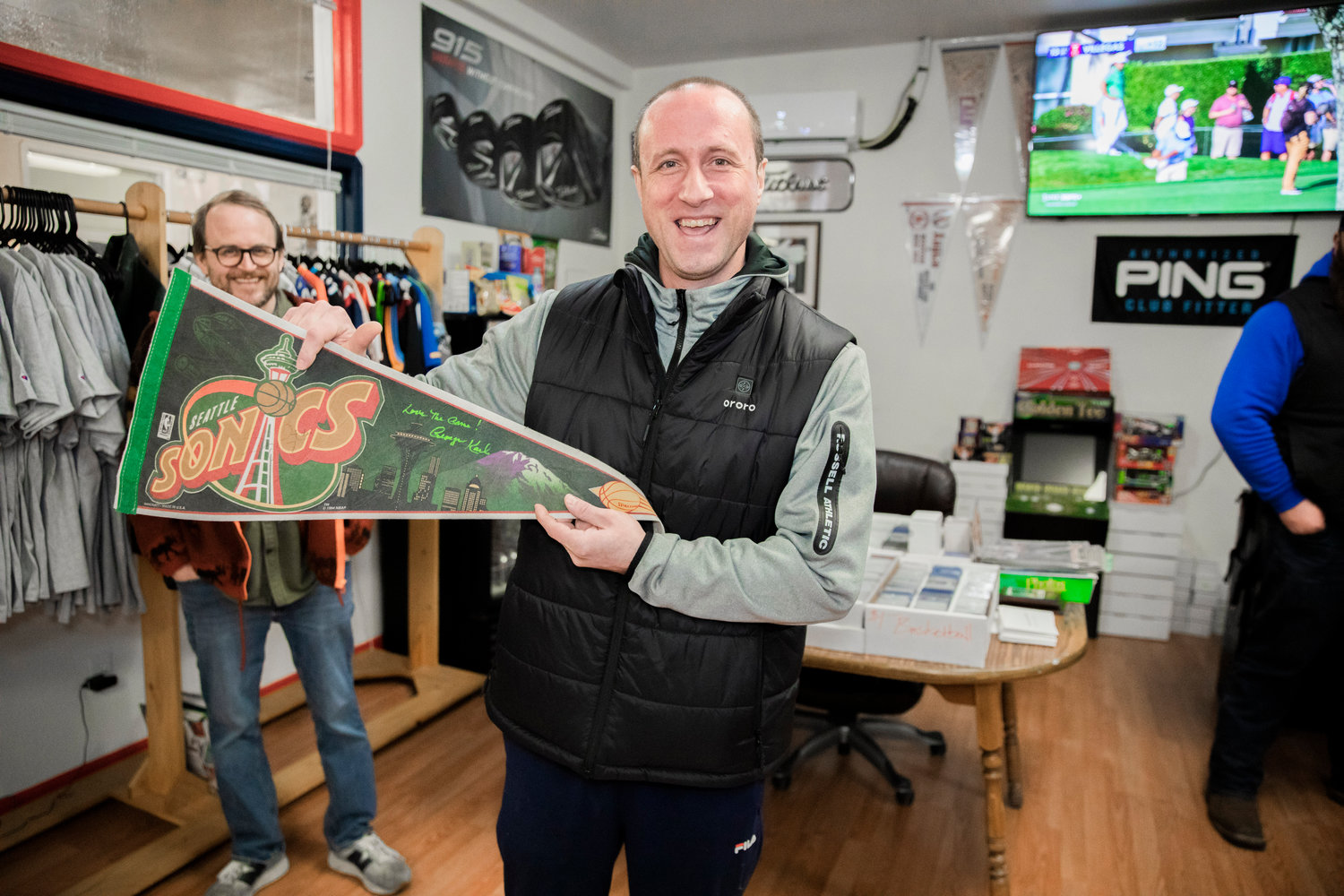 Ryan Guenther holds up a Seattle Sonics banner he has had for over 20 years, after it was autographed by George Karl on Friday, at Keiper’s Cards in Centralia.